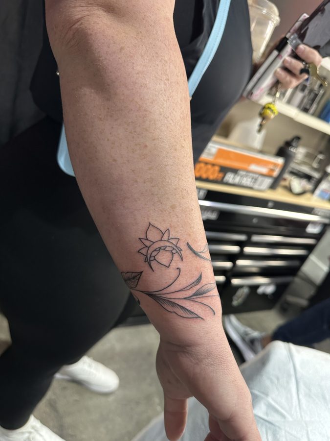 A lotus tattoo on a member's wrist